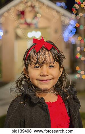 Hispanic girl smiling outside house decorated with string lights View Large Photo Image Stock Photo - Hispanic girl smiling outside house decorated with string lights. Fotosearch