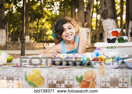 Stock Photo - Hispanic girl smiling with Easter eggs. Fotosearch