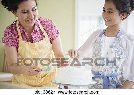 Hispanic mother and daughter decorating cake together View Large Photo Image Stock Photo - Hispanic mother and daughter decorating cake together. Fotosearch