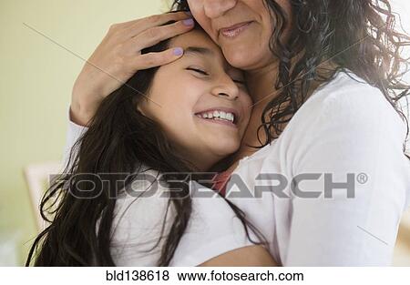 Stock Photo - Hispanic mother and daughter hugging. Fotosearch