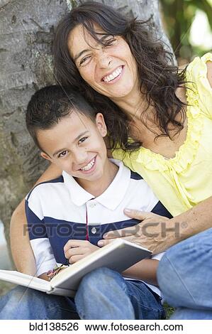 Stock Photograph - Hispanic mother and son reading book. Fotosearch