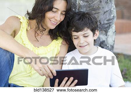 Hispanic mother and son reading digital tablet View Large Photo Image Stock Photo - Hispanic mother and son reading digital tablet. Fotosearch