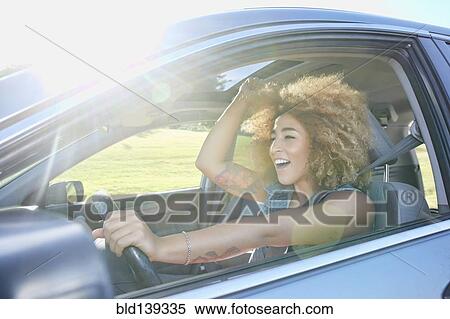 Hispanic woman cheering and driving car View Large Photo Image Stock Photography - Hispanic woman cheering and driving car. Fotosearch
