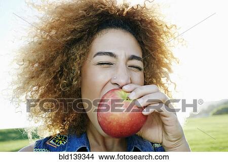 Hispanic woman eating apple outdoors View Large Photo Image Picture - Hispanic woman eating apple outdoors. Fotosearch