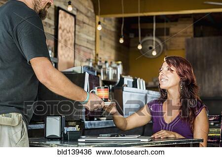 Stock Photograph - Hispanic woman having coffee in cafe. Fotosearch