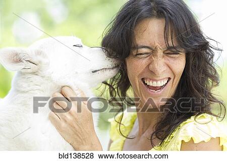 Stock Photo - Hispanic woman playing with dog. Fotosearch