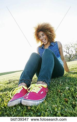 Hispanic woman sitting in field View Large Photo Image Stock Photo - Hispanic woman sitting in field. Fotosearch