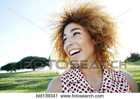 Stock Image - Hispanic woman smiling outdoors. Fotosearch