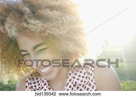 Stock Image - Hispanic woman smiling outdoors. Fotosearch