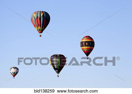 Stock Photo - Hot air balloons floating in blue sky. Fotosearch