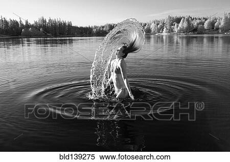 Stock Photography - Korean woman flipping hair in lake. Fotosearch