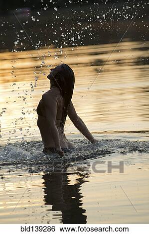 Stock Photograph - Korean woman playing in lake. Fotosearch