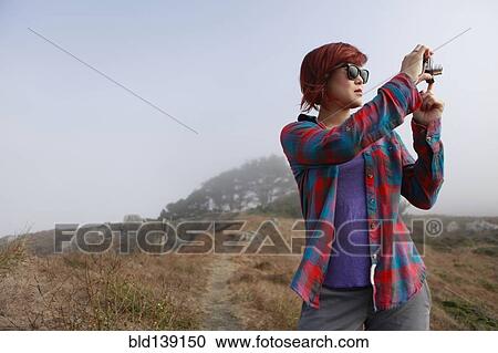 Korean woman taking photograph in remote landscape View Large Photo Image Stock Image - Korean woman taking photograph in remote landscape. Fotosearch