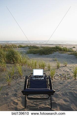 Laptop on deck chair overlooking beach View Large Photo Image Stock Image - Laptop on deck chair overlooking beach. Fotosearch