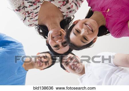 Stock Photograph - Low angle view of Hispanic family smiling. Fotosearch