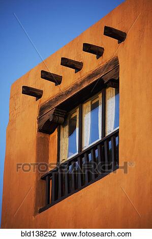 Stock Image - Low angle view of posts and window in adobe house. Fotosearch