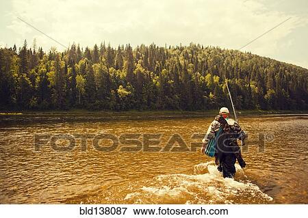 Mari fisherman carrying fishing rod in lake View Large Photo Image Stock Photo - Mari fisherman carrying fishing rod in lake. Fotosearch