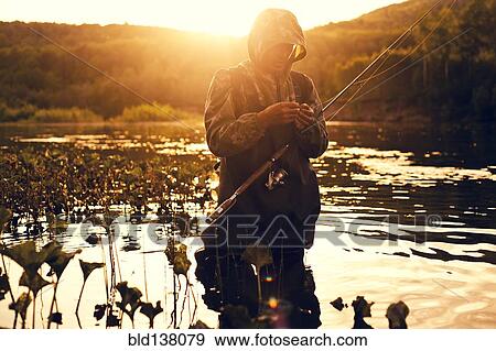 Stock Photo - Mari fisherman preparing hook in lake . Fotosearch