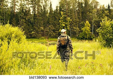 Stock Image - Mari fisherman walking through field. Fotosearch