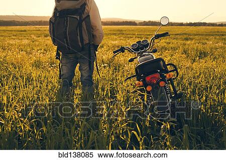 Mari man standing in field with motorcycle View Large Photo Image Stock Photography - Mari man standing in field with motorcycle. Fotosearch