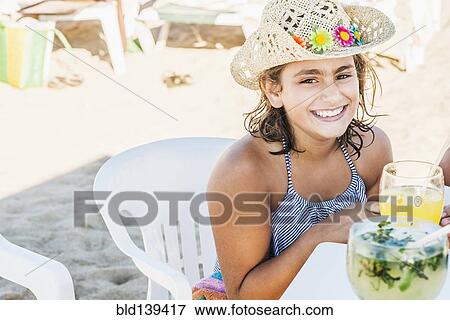 Stock Photo - Mixed race girl wearing cowboy hat at table. Fotosearch