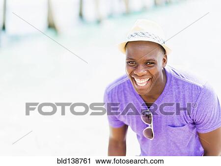Stock Image - Mixed race man at beach. Fotosearch