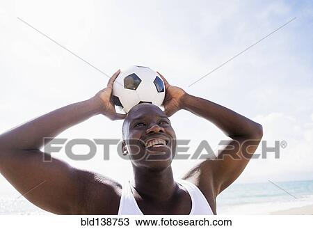 Mixed race man holding soccer ball on beach View Large Photo Image Stock Image - Mixed race man holding soccer ball on beach. Fotosearch