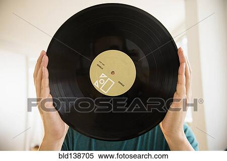 Mixed race man obscuring face with vinyl record View Large Photo Image Stock Photography - Mixed race man obscuring face with vinyl record. Fotosearch