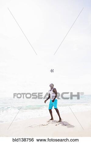 Mixed race man playing with soccer ball on beach View Large Photo Image Stock Photograph - Mixed race man playing with soccer ball on beach. Fotosearch