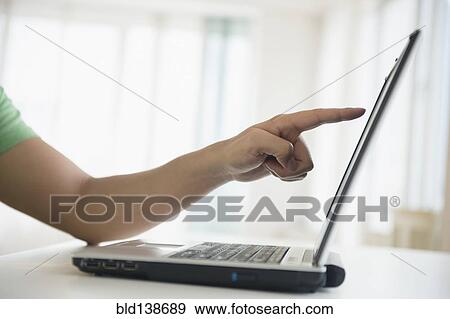 Stock Photo - Mixed race man pointing to laptop screen. Fotosearch