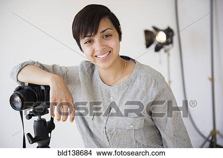 Mixed race photographer smiling in studio View Large Photo Image Picture - Mixed race photographer smiling in studio. Fotosearch