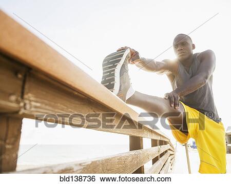 Mixed race runner stretching leg on banister View Large Photo Image Stock Photograph - Mixed race runner stretching leg on banister. Fotosearch