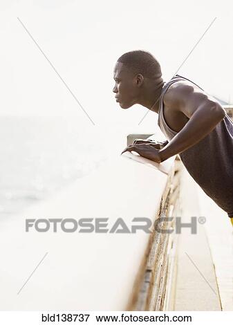 Mixed race runner stretching on banister View Large Photo Image Stock Photo - Mixed race runner stretching on banister. Fotosearch