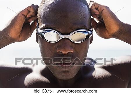 Mixed race swimmer putting on goggles View Large Photo Image Stock Image - Mixed race swimmer putting on goggles. Fotosearch