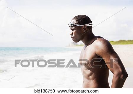 Mixed race swimmer wearing goggles at beach View Large Photo Image Stock Image - Mixed race swimmer wearing goggles at beach. Fotosearch