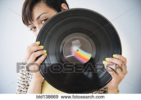Mixed race woman holding vinyl record View Large Photo Image Stock Photo - Mixed race woman holding vinyl record. Fotosearch