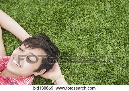 Mixed race woman laying in grass outdoors View Large Photo Image Stock Photo - Mixed race woman laying in grass outdoors. Fotosearch