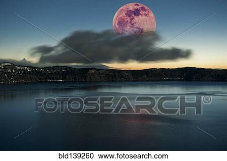 Stock Image - Moon over dark cloud at Crater Lake, Oregon, United States. Fotosearch