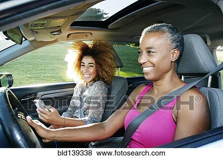 Stock Photo - Mother and daughter driving car. Fotosearch