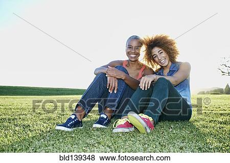 Stock Photo - Mother and daughter sitting in field. Fotosearch