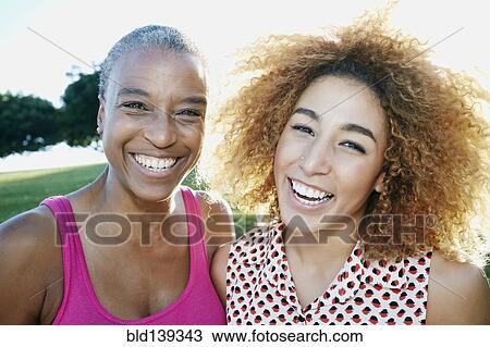 Stock Image - Mother and daughter smiling outdoors. Fotosearch