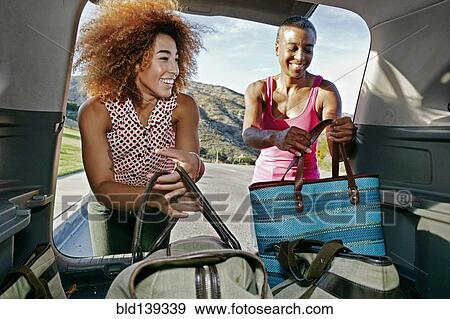 Mother and daughter unloading bags from car View Large Photo Image Stock Photo - Mother and daughter unloading bags from car. Fotosearch