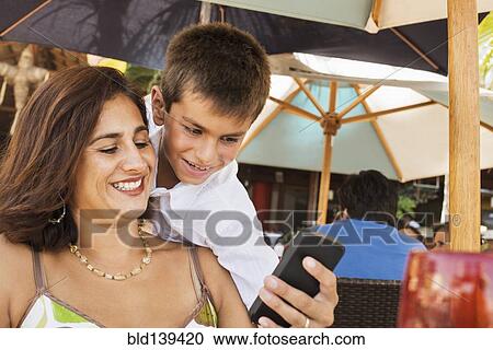 Stock Image - Mother and son using cell phone. Fotosearch