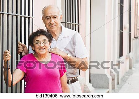Stock Photograph - Older couple smiling together near gate. Fotosearch