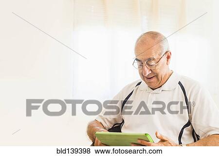 Older Hispanic man using digital tablet View Large Photo Image Stock Photo - Older Hispanic man using digital tablet. Fotosearch