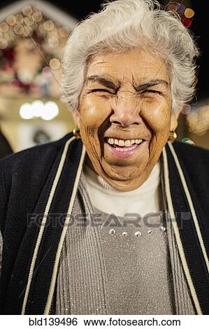 Older Hispanic woman smiling outside house decorated with string lights View Large Photo Image Stock Photograph - Older Hispanic woman smiling outside house decorated with string lights. Fotosearch
