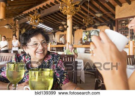 Stock Photo - Older woman laughing in restaurant. Fotosearch