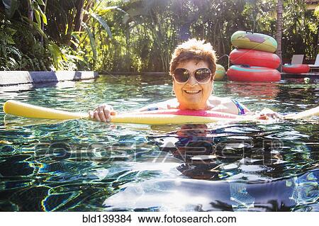 Older woman with sunglasses in swimming pool View Large Photo Image Picture - Older woman with sunglasses in swimming pool. Fotosearch