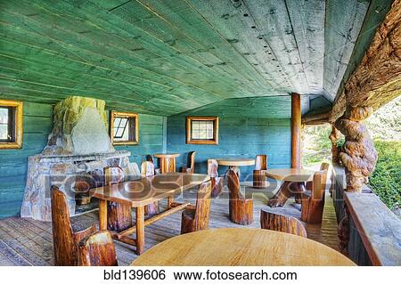 Stock Photograph - Rustic chairs and tables on restaurant patio. Fotosearch