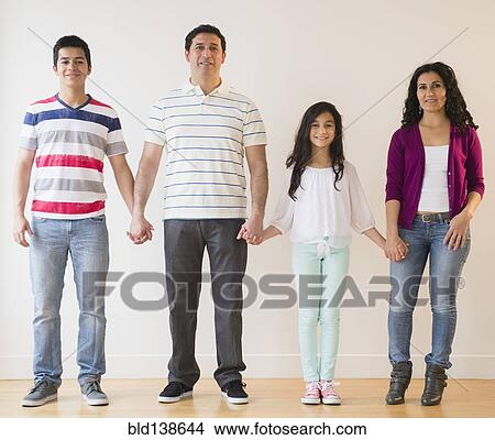 Smiling Hispanic family holding hands View Large Photo Image Picture - Smiling Hispanic family holding hands. Fotosearch
